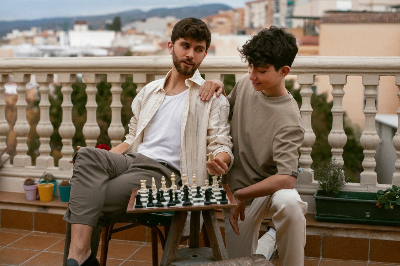 Father teaching his son how to play chess after drinking mushroom coffee to increase mental focus