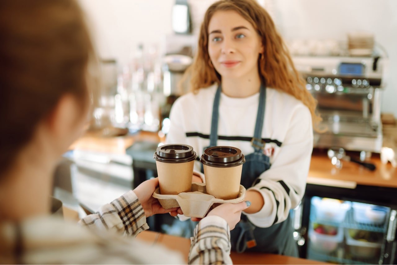 woman purchasing mushroom coffee from barista after asking for the cost of mushroom coffee